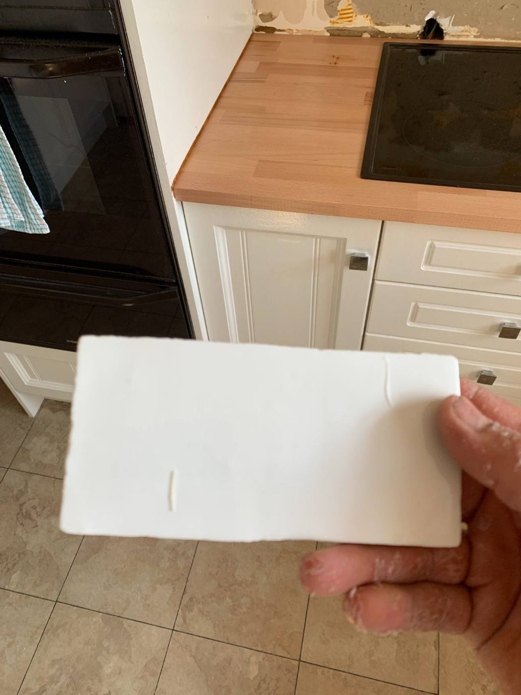 White subway tile sample held against a new timber benchtop by Loel Homes