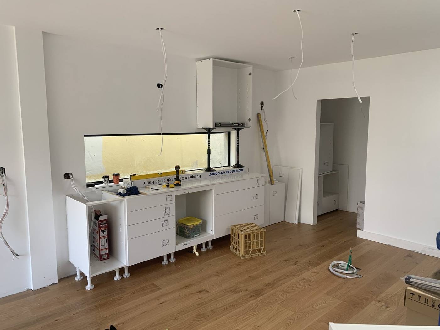 Open-plan living and kitchen with island base and cabinetry roughed in and timber floors laid, Dulwich Hill by Loel Homes