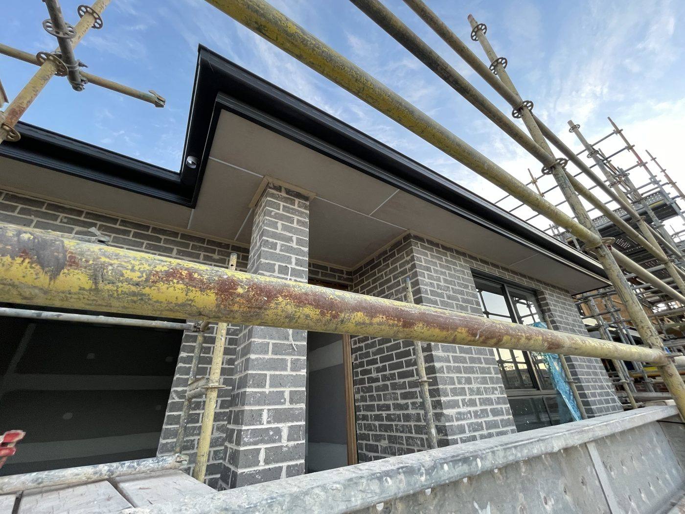 Brickwork up to the corner with new dark fascia and eaves on a two-storey new build by Loel Homes
