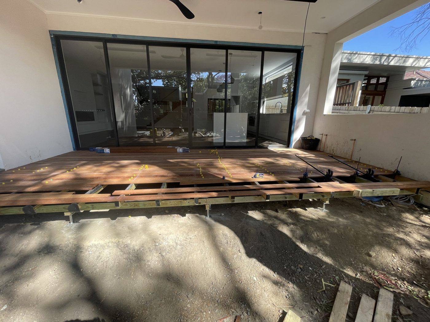 First hardwood deck boards going down over the joists at the rear of the home by Loel Homes