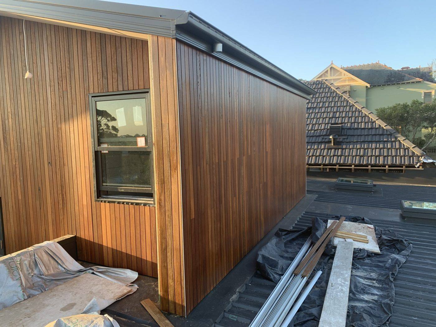Vertical spotted gum timber cladding wrapping an upper-floor addition with a black-framed window, luxury home by Loel Homes