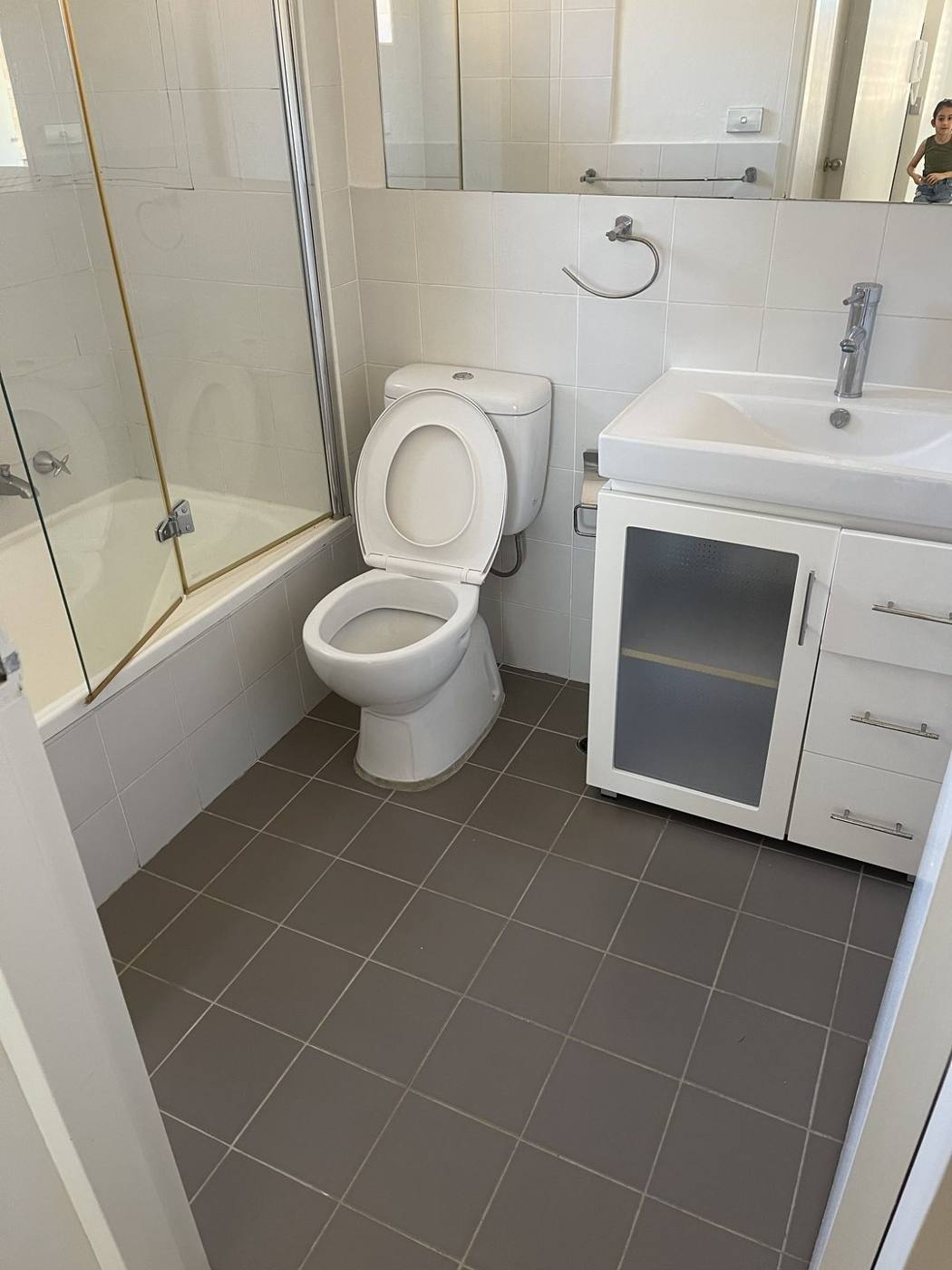 Dated original bathroom before renovation with beige tiles, over-bath shower screen and old vanity, Top Ryde by Loel Homes